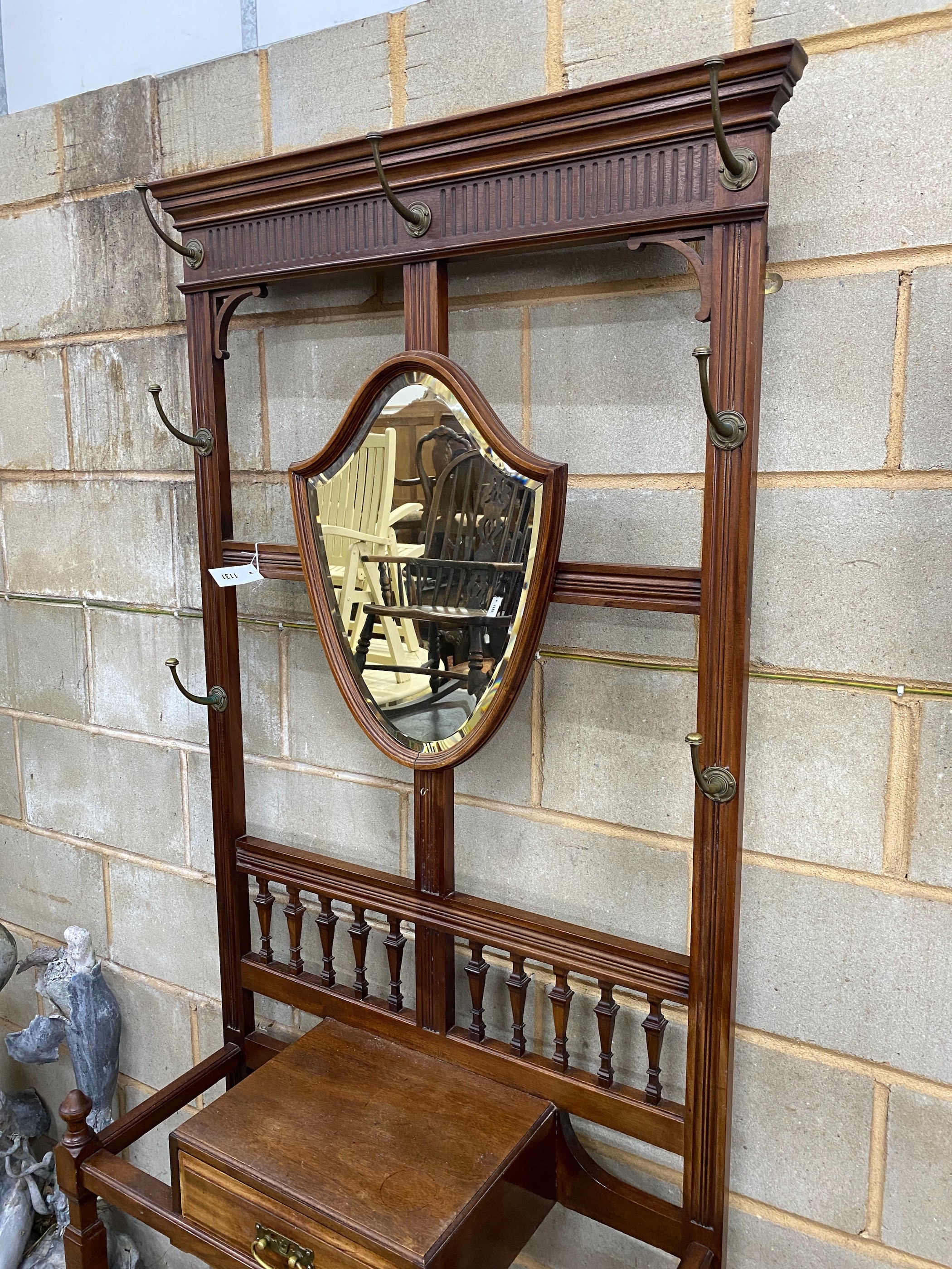 A late Victorian mahogany hall stand with shield silvered mirror, width 84cm, height 203cm